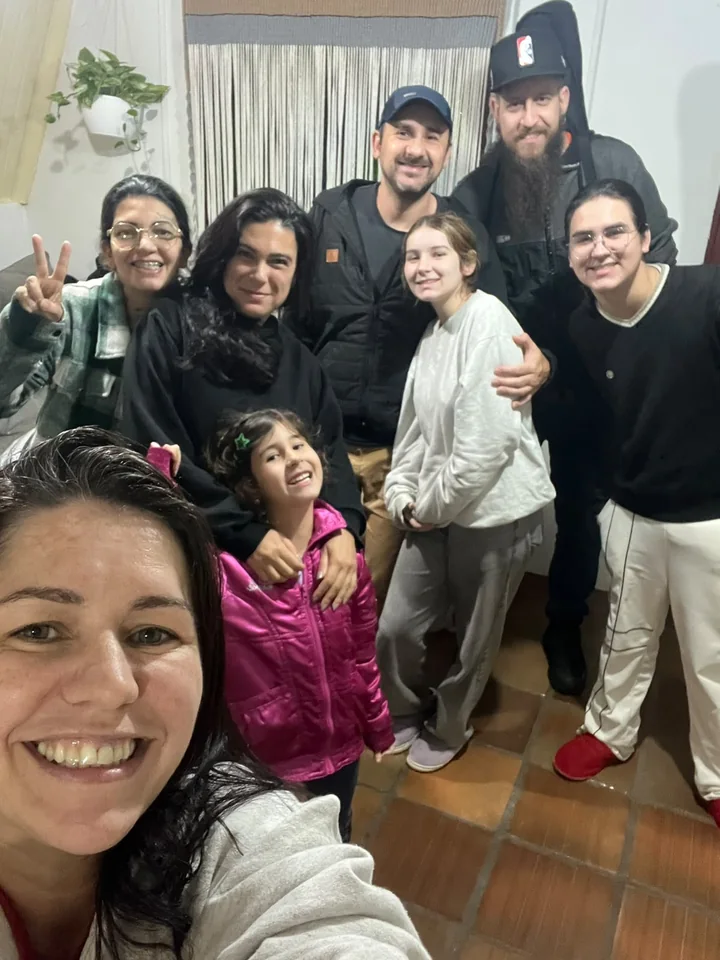 Pessoas de diferentes idades próximas umas das outras, sorrindo para uma foto de grupo