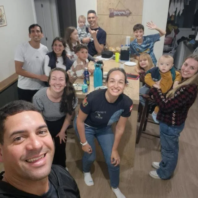Adultos e crianças reunidos ao redor de uma mesa