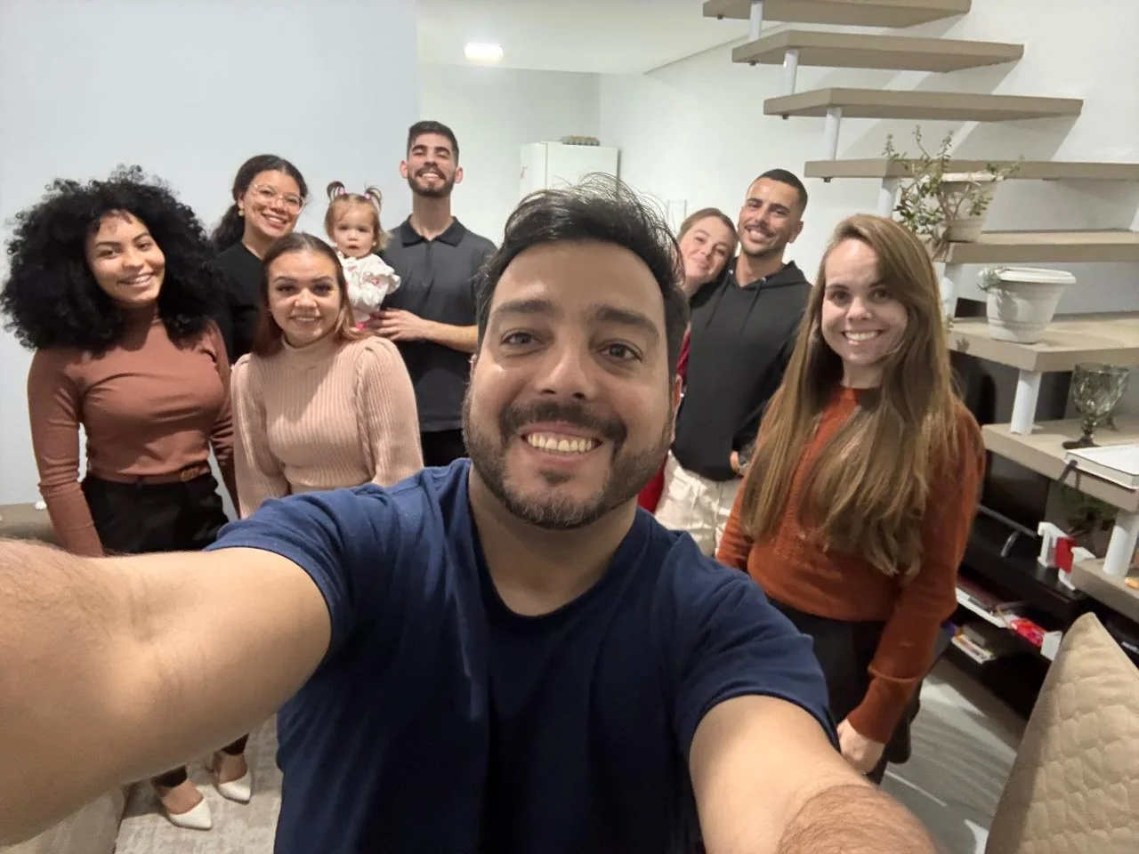 Grupo de adultos e uma criança reunidos para uma foto em ambiente interno