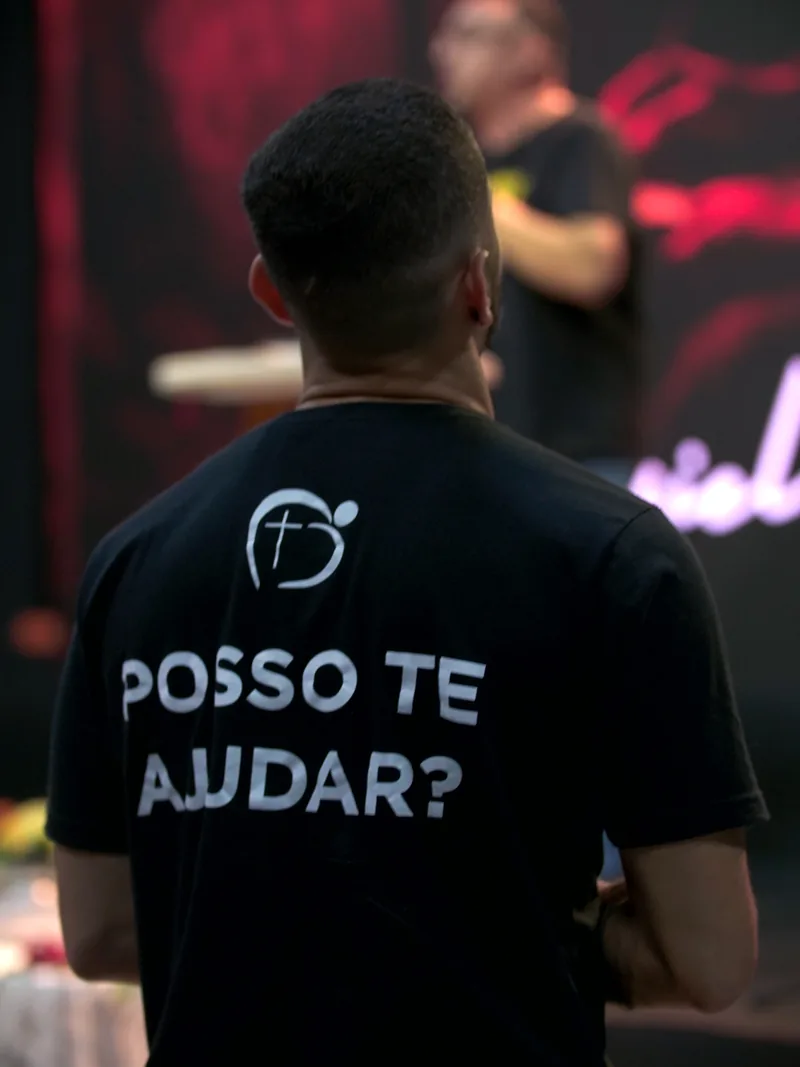 Voluntário da Zoe com a mensagem Posso te ajudar? na camiseta